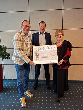 Spendenübergabe mit symbolischen Scheck